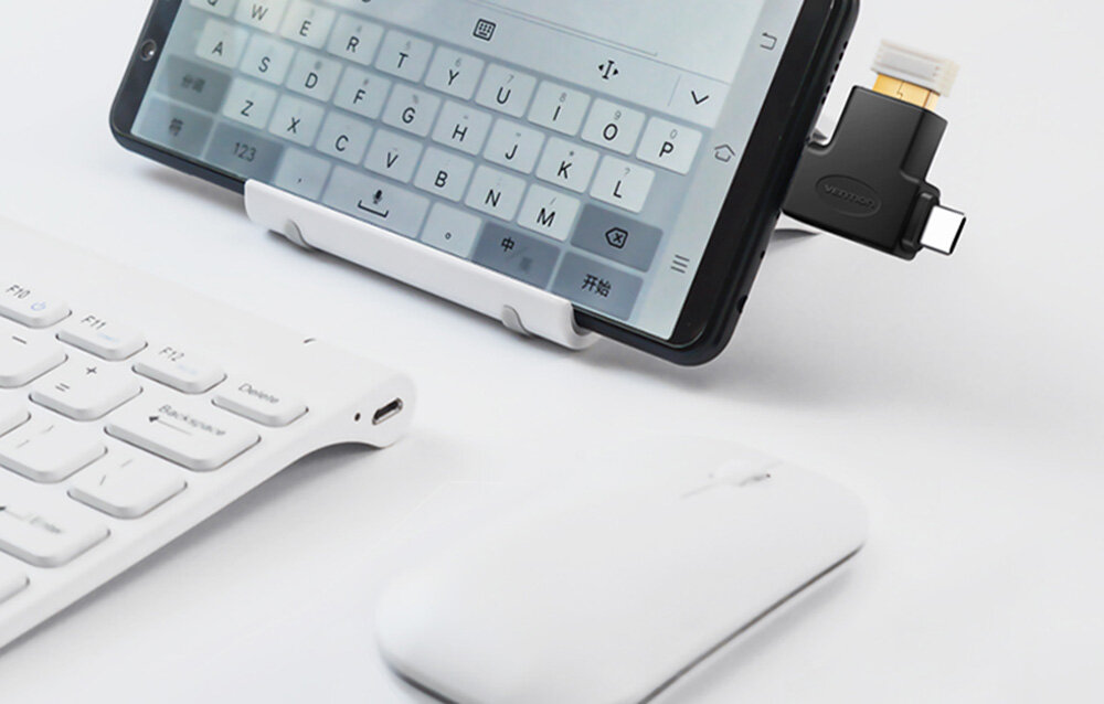 Na obrazie widać smartfon z podłączonym adapterem OTG, klawiaturę i myszkę. Adapter ma logo \'vention\'.
