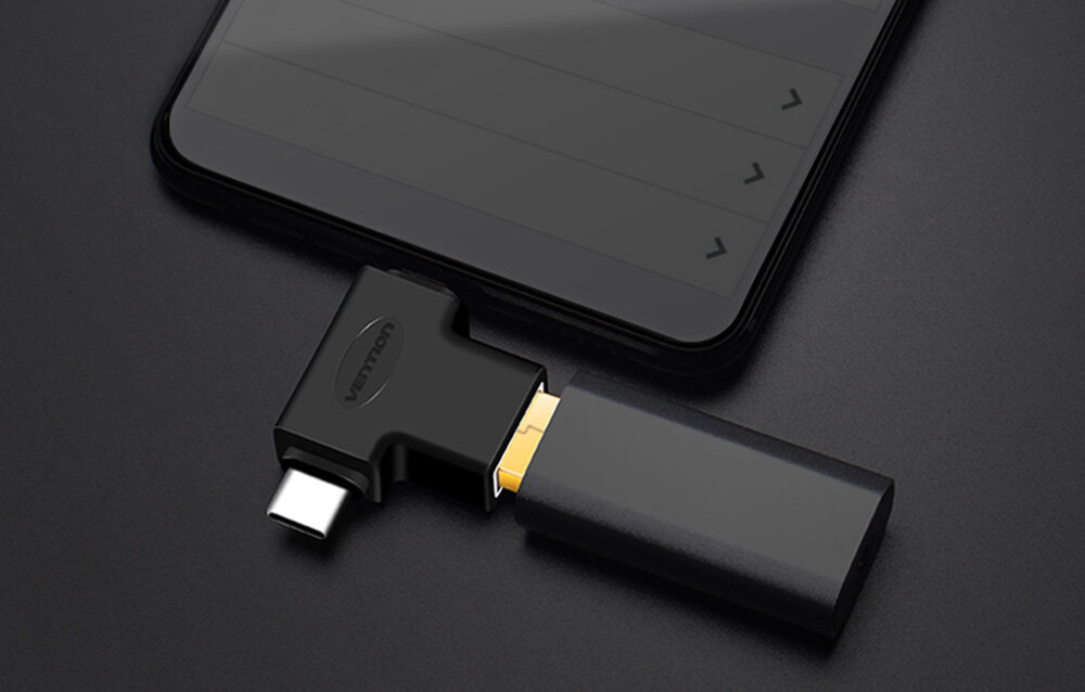 Na ciemnym tle widać adapter USB-C z logo \'vention\', podłączony do smartfona oraz urządzenie USB wpięte do adaptera.