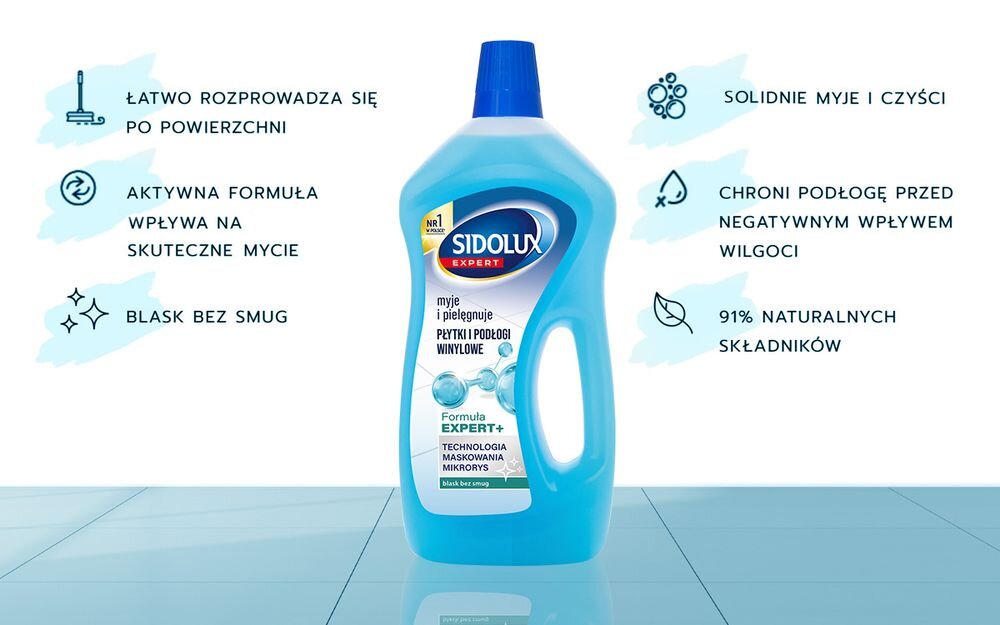 Na obrazie znajduje się butelka płynu do mycia podłóg SIDOLUX Expert Plus Płytki i winyle 750 ml z niebieską etykietą. Obok butelki widoczne są hasła: \'Łatwo rozprowadza się po powierzchni\', \'Aktywna formuła wpływa na skuteczne mycie\', \'Blask bez smug\', \'Solidnie myje i czyści\', \'Chroni podłogę przed negatywnym wpływem wilgoci\', \'91% naturalnych składników\'.