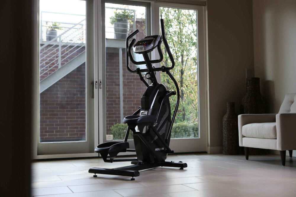 Orbitrek HORIZON FITNESS HT 5.0 Peak Trainer maszyna w pomieszczeniu stoi na podłodze efektywny trening cardio ruch eliptyczny stepper angażuje całe ciało niewielkie wymiary w domowych warunkach