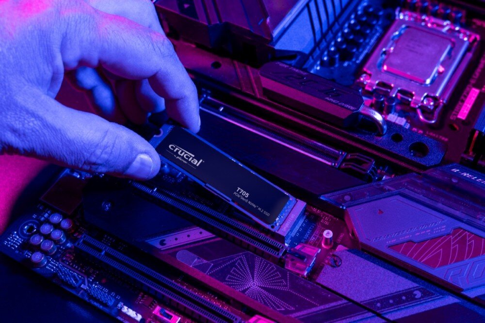 Dysk CRUCIAL T705 Ręka wkładająca dysk SSD 'T705' do złącza na płycie głównej komputera, całość oświetlona na fioletowo-niebiesko, wydajność, szybkość, cechy