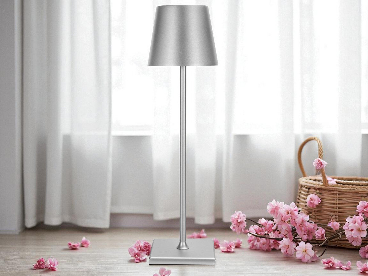 Lampka stołowa LIN Moonlight 8010 Srebrny, barwa, lumeny, natężenie, regulacja, lampką stoi na podłodze przy kwiatach i oknie dziennym