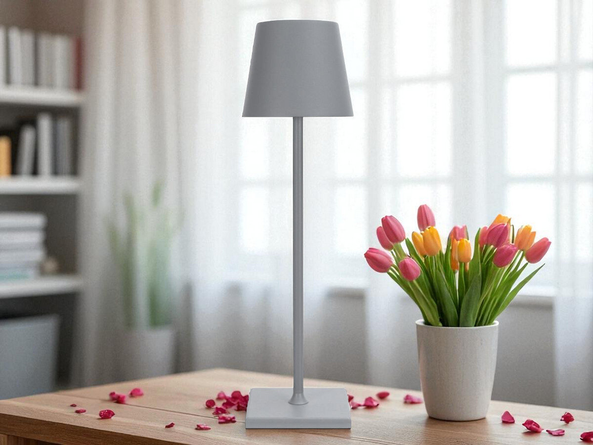 Lampka stołowa LIN Moonlight 8012 Szary, bezprzewodowo, bateria, usb-c, waga, lampka stoi na stole w pokoju dziennym wraz z wazonem kwiatów