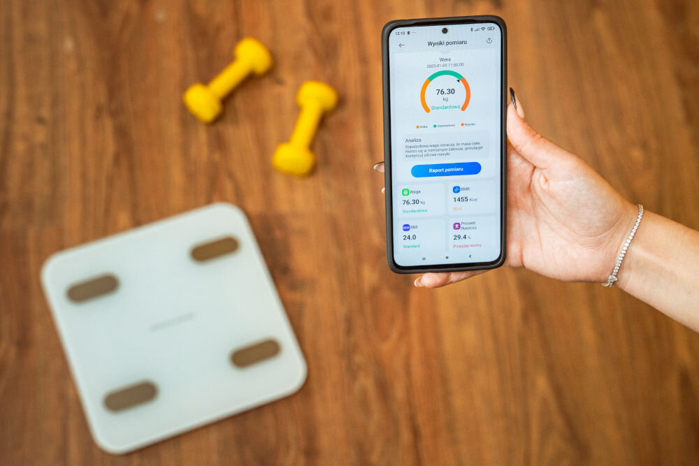 Waga łazienkowa GÖTZE & JENSEN Analizator BT BS700W Biały telefon z aktywną aplikacją prezentującą skład ciała w tle hantelki