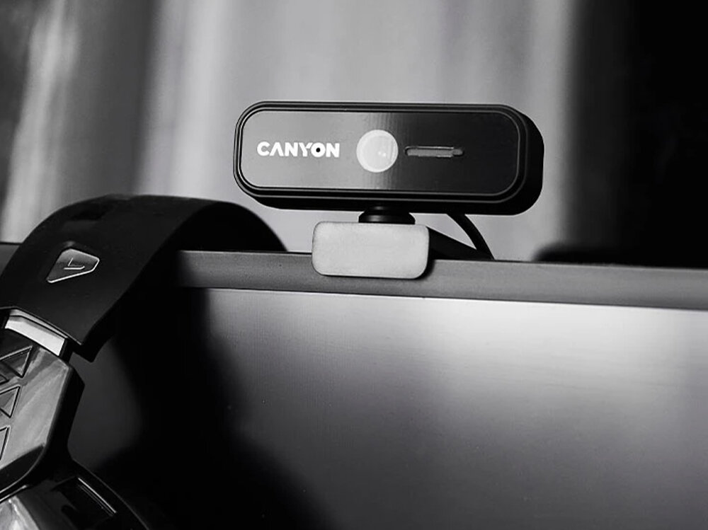 Kamera CANYON C2N USB-A - 1080p, 1920x1080, detale, ostrość, jakość, Zbliżenie na kamerę na monitorze, w tle słuchawki.