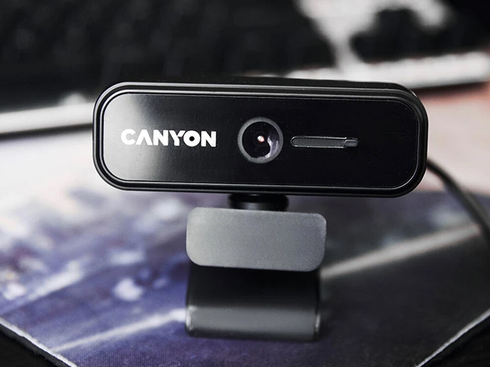 Kamera CANYON C2N USB-A - 1080p, mikrofon, redukcja szumów, audio, rozmowy, Kamera na laptopie widoczna na tle biurka.