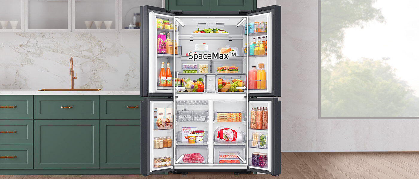 Otwarta lodówka z widocznymi półkami wypełnionymi różnorodnymi produktami spożywczymi, napojami i pojemnikami. Na wewnętrznej stronie drzwi widoczny jest napis \'SpaceMax™\'.