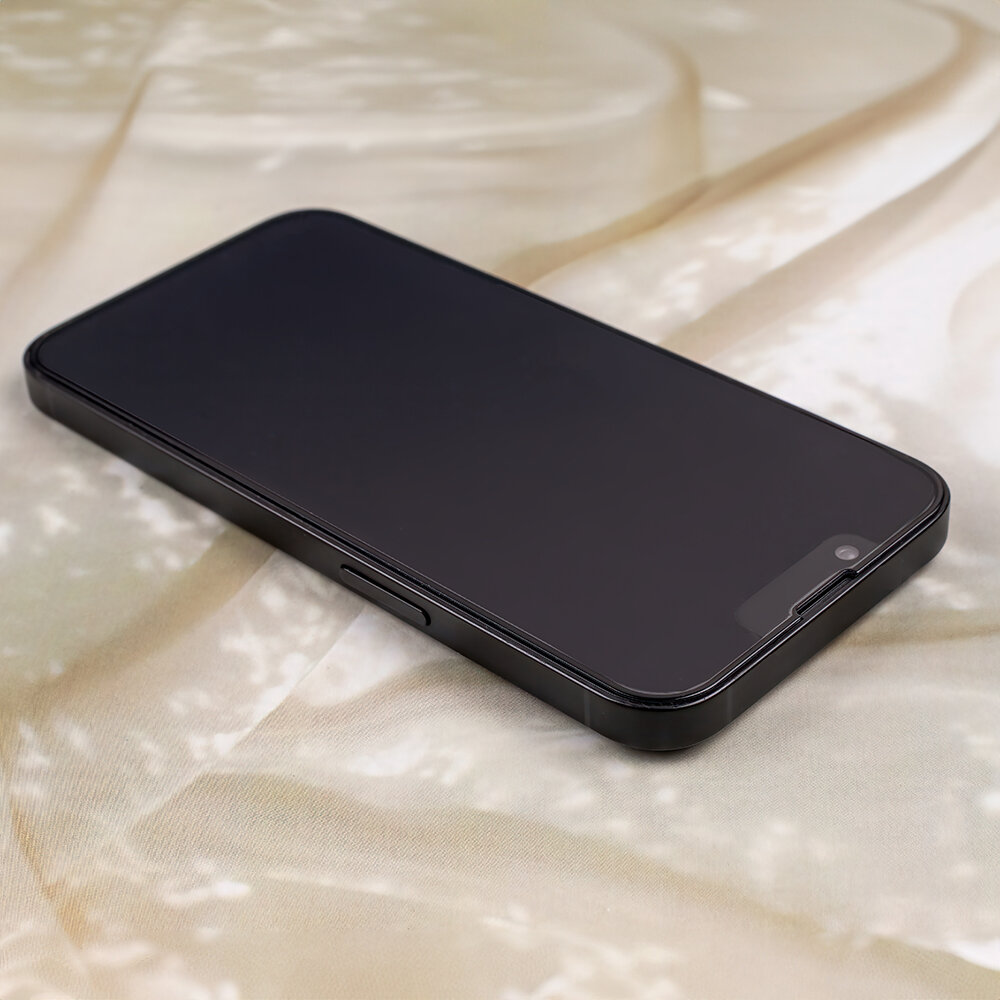 Na obrazie widoczny jest smartfon z ciemnym ekranem, leżący na jasnym tle. Telefon ma prostokątny kształt z zaokrąglonymi rogami.