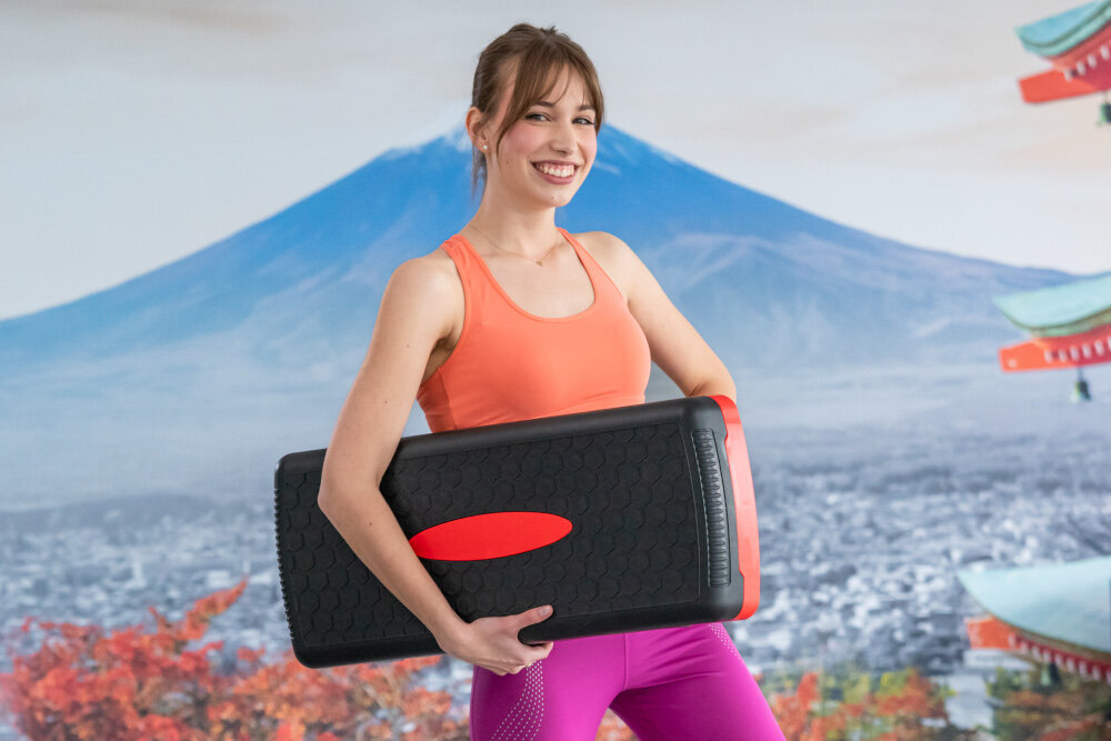 Step S_LINE SA022BG Czarno-różowy sala gimnastyczna osoba trzyma step w dłoniach bezpieczny trening dynamika zdrowie ćwiczenia