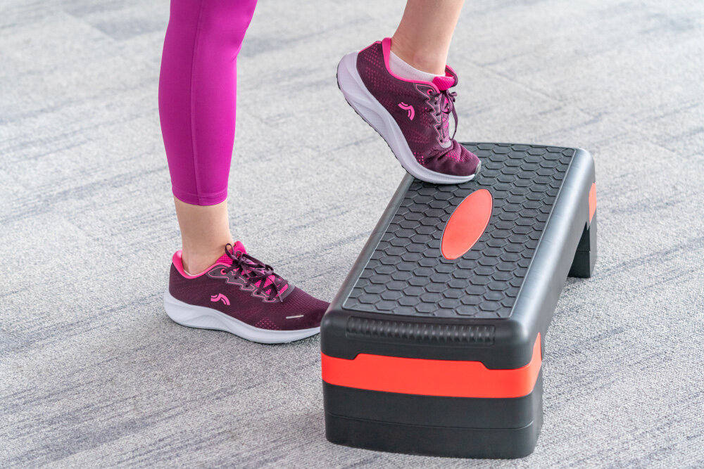 Step S_LINE SA022BG Czarno-różowy sala gimnastyczna osoba ćwiczy na stepie jedna zbliżenie na stopy powierzchnia 81 × 28 cm antypoślizgowa struktura platformy pewność ruchu