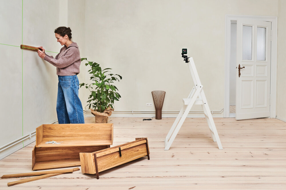 Laser krzyżowy BOSCH Quigo Green Set 0603663CZ1 pomieszczenie osoba wyznacza linie na ścianie wokół meble kwiaty drabina aluminiowy statyw praca na wysokości od 0,37 m do 1,1 m stabilne ustawienie lasera