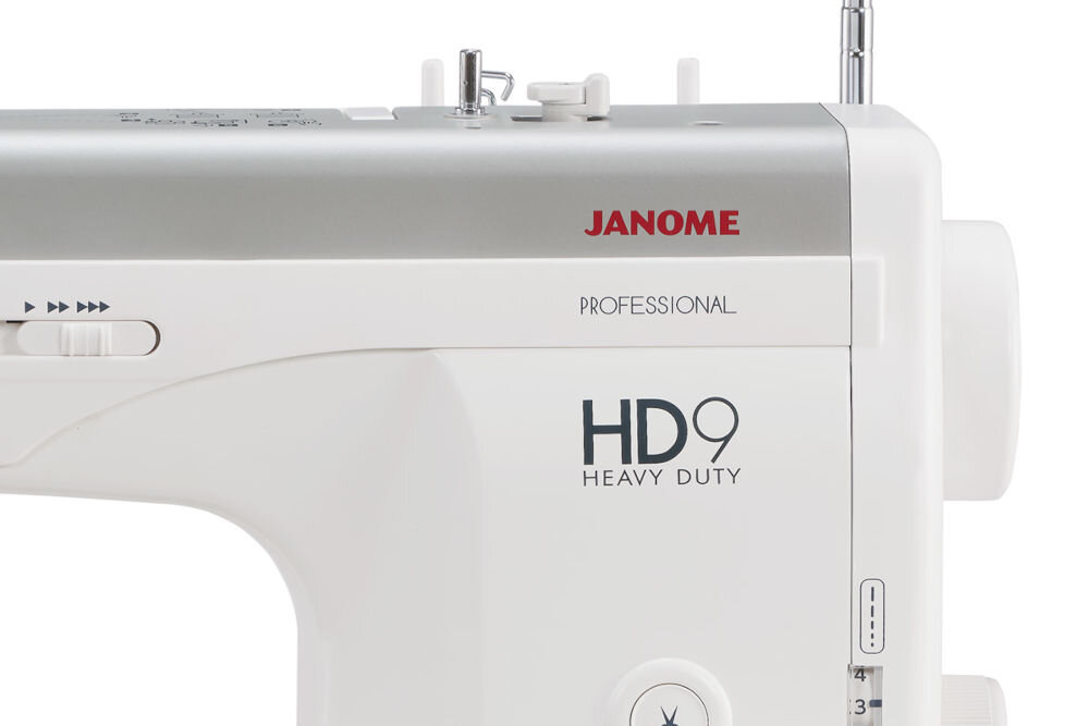 Maszyna do szycia JANOME HD9 Professional zbliżenie na napis biało szara obudowa metalowe elementy pokrętła przyciski suwak białe tło z serii Professional Heavy Duty do intensywnego użytkowania w warunkach domowych i profesjonalnych w pełni metalowa konstrukcja trwałość wytrzymałość moc mocny silnik wszechstronne narzędzie