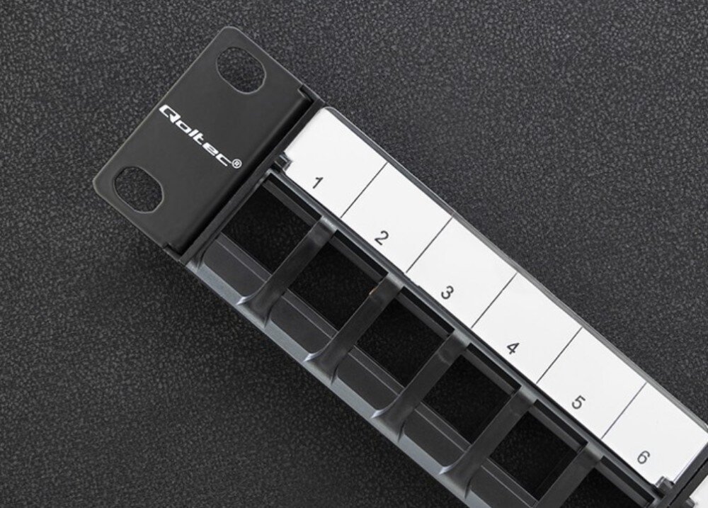 Patch panel QOLTEC 54516 Zbliżenie na fragment czarnego panelu z białymi polami opisowymi ponumerowanymi od 1 do 6 oraz logo producenta umieszczone z boku, zastosowanie, kompatybilność
