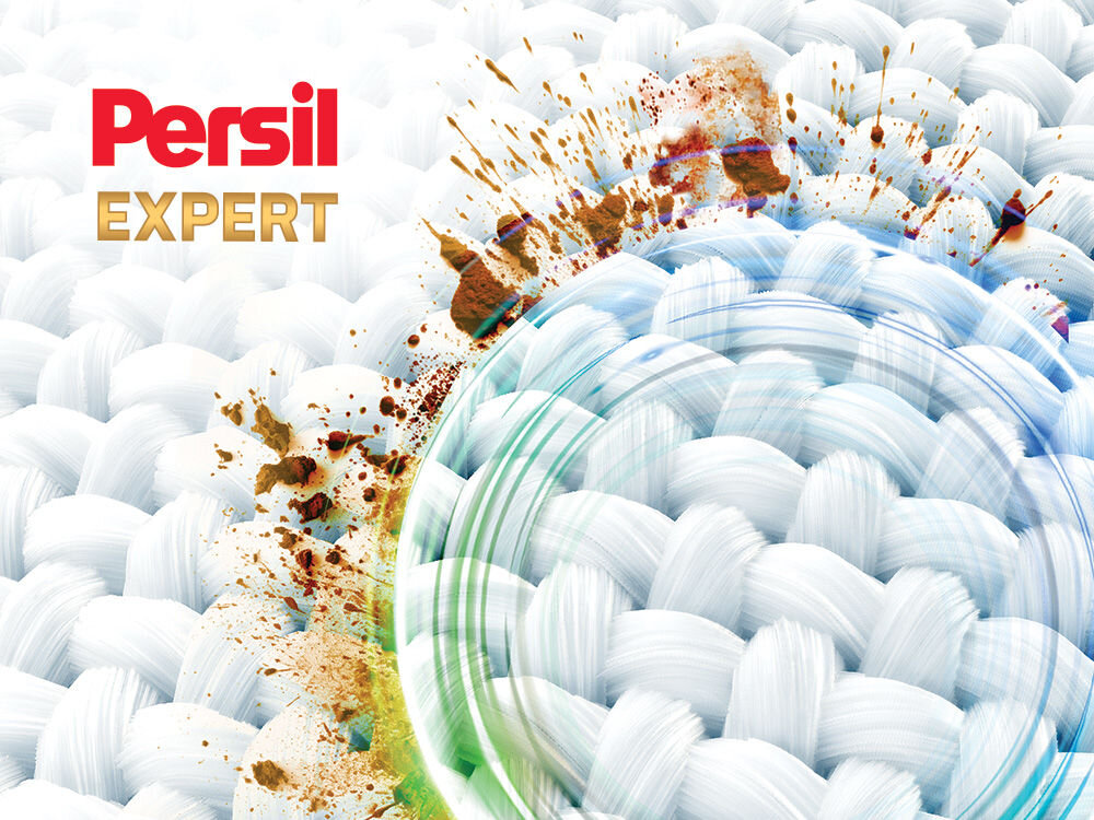 Kapsułki do prania PERSIL Zdjęcie ilustrujące działanie Persil Expert. Powiększenie struktury tkaniny z widocznymi, rozpryskanymi plamami brudu. Część plam jest usuwana przez niewidoczną siłę w kształcie błękitno-zielonego pierścienia, symbolizującego głębokie czyszczenie. Logo: Persil Expert