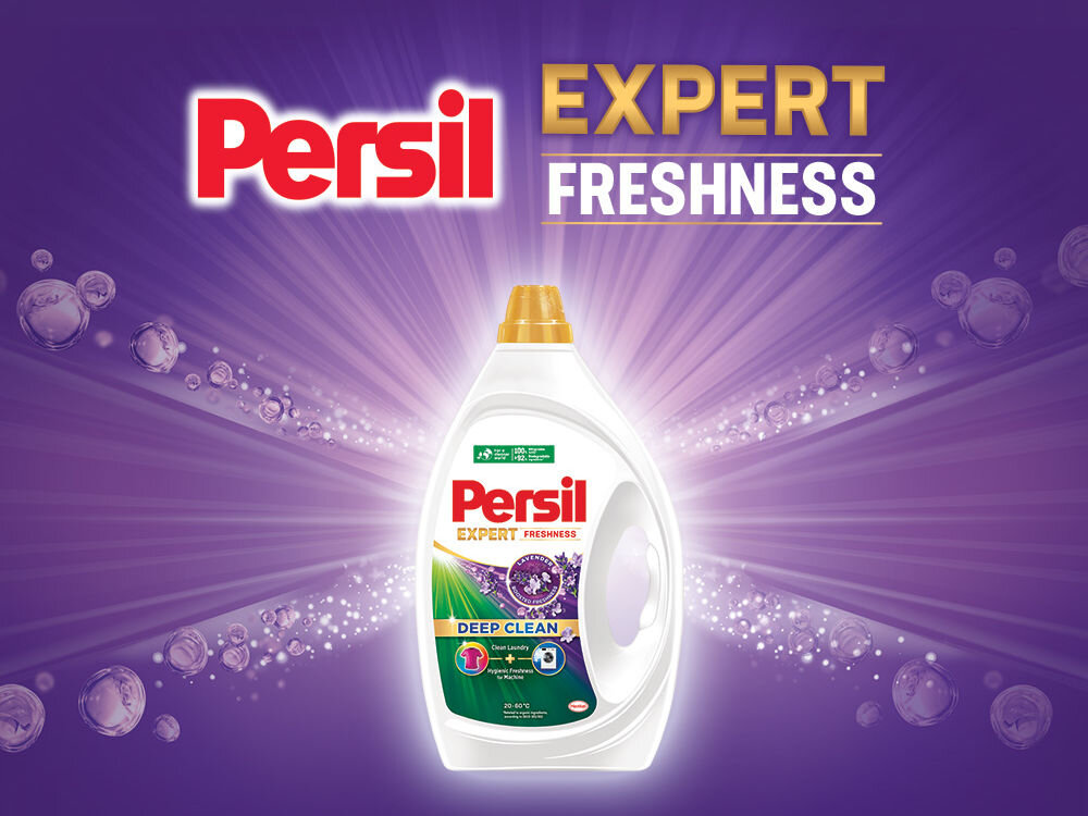 Żel do prania PERSIL Reklama żelu Persil Expert Freshness. Duża butelka żelu na fioletowym tle z bąbelkami i promieniami światła. Na butelce widoczny napis Hygienic Freshness (Higieniczna świeżość)