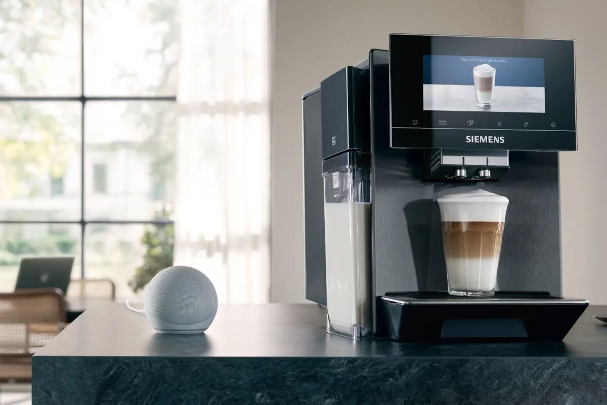 SIEMENS serii EQ900 Plus - ekpres po przygotowaniu napoju na blacie, w tle widać okno