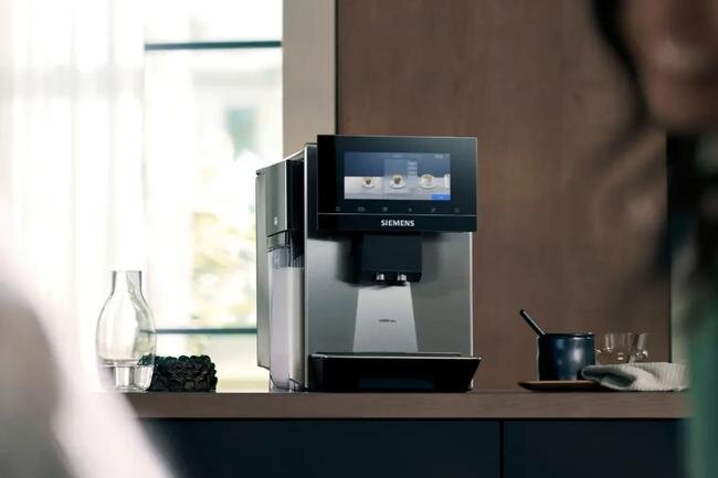 SIEMENS serii EQ900 Plus - ekspres na drugim planie na blacie