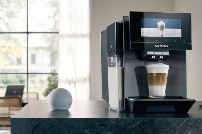SIEMENS serii EQ900 Plus - ekpres po przygotowaniu napoju na blacie, w tle widać okno