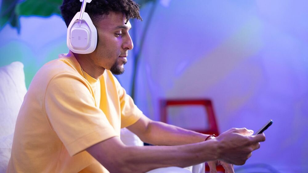 Słuchawki LOGITECH Astro A50 X z Bluetooth, miksem czatu Discord i dźwięku gry, osoba z założonymi słuchawkami