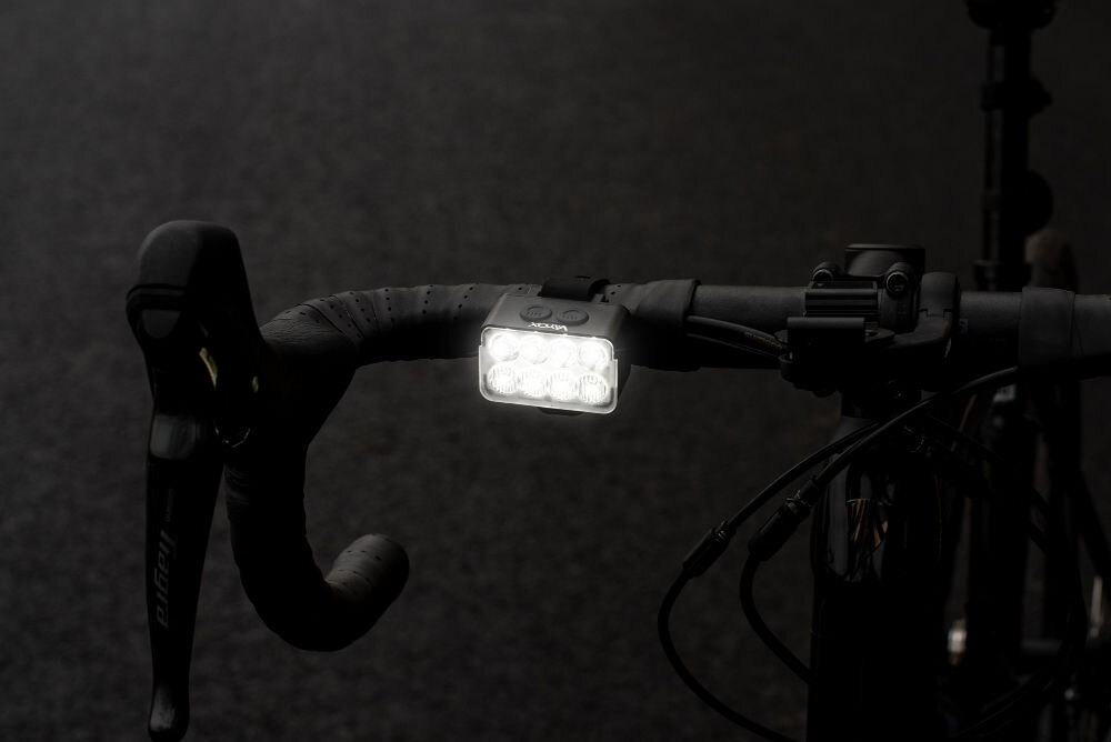 Lampka rowerowa VAYOX VA0151 na kierownicy w ciemnym otoczeniu czas działania do 3 godzin pełna moc do 28 godzin tryb oszczędny ładowanie usb-c