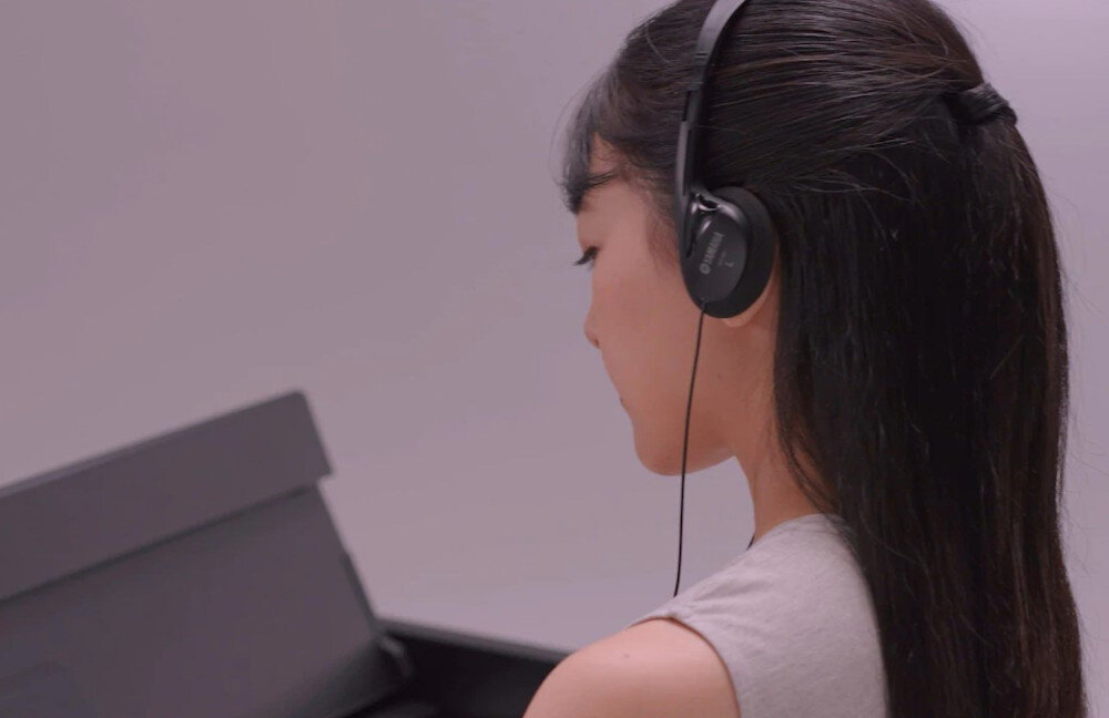 Pianino cyfrowe YAMAHA YDP-S35WA - Komfort podczas gry na słuchawkach, KOBIETA W SŁUCHAWKACH siedząca przy fortepianie