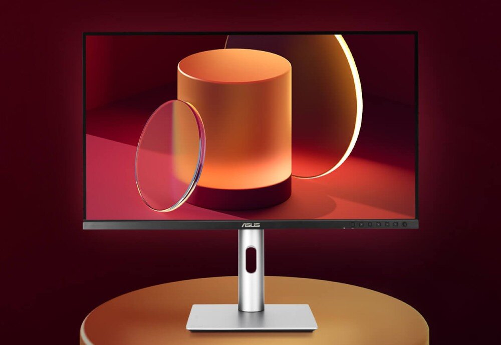 Monitor ASUS ProArt PA24ACRV Monitor stojący na okrągłym podwyższeniu. Na wyświetlaczu widoczne są trójwymiarowe figury geometryczne w postaci walca i koła