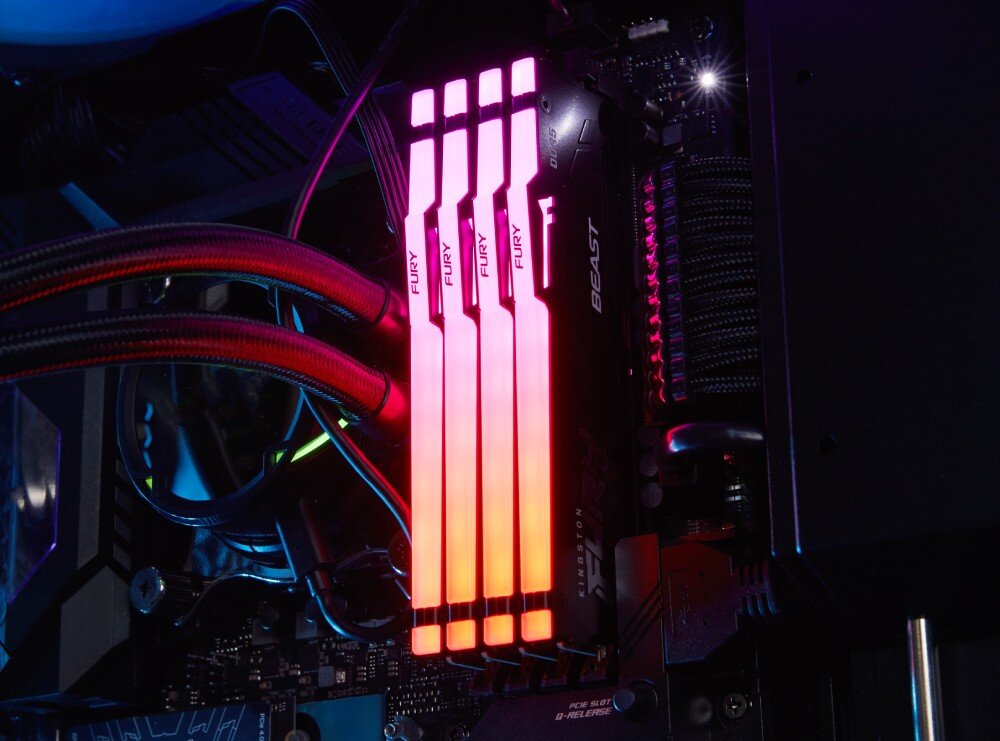 Pamięć RAM KINGSTON Fury Beast RGB Cztery moduły pamięci w ciemnym wnętrzu komputera świecące intensywnym czerwonym światłem