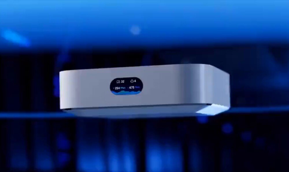 Router UBIQUITI UniFi Express (UX-EU) Białe urządzenie sieciowe lewitujące w powietrzu na ciemnym tle, z małym wyświetlaczem pokazującym parametry sieci