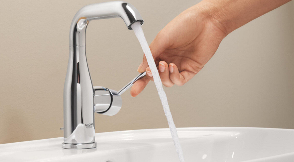 BATERIA UMYWALKOWA GROHE ESSENCE ROZMIAR M 23462001 CHROM Zdjęcie przedstawia zbliżenie na baterię w momencie regulacji strumienia wody za pomocą bocznej dźwigni estetyka GROHE Essence chromowana powłoka oszczędność wody płynna obsługa