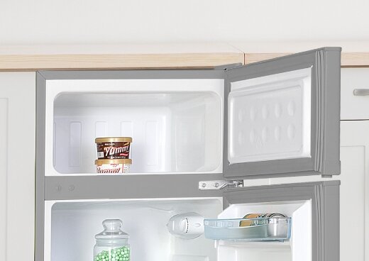 Zbliżenie na zamrażalnik górny lodówki MPM-87-CZ-13/E, w którym znajdują się lody.