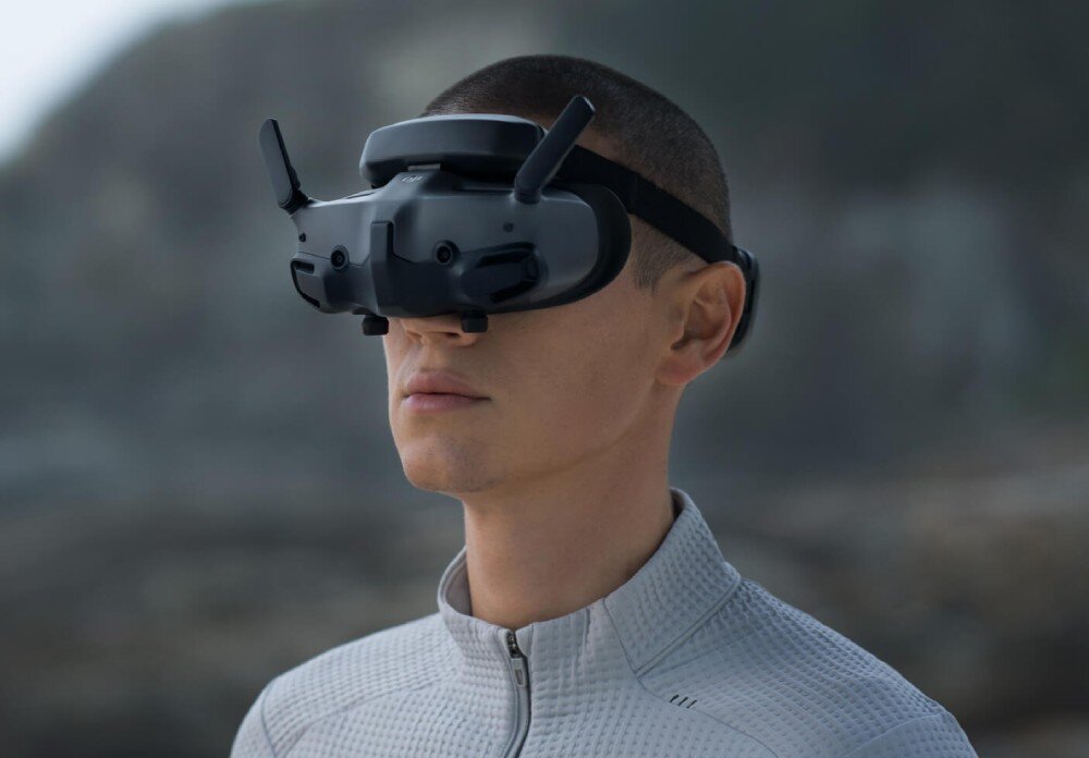 Gogle DJI Goggles 3 Profil osoby w goglach z dwiema uniesionymi antenami, tło jest rozmyte
