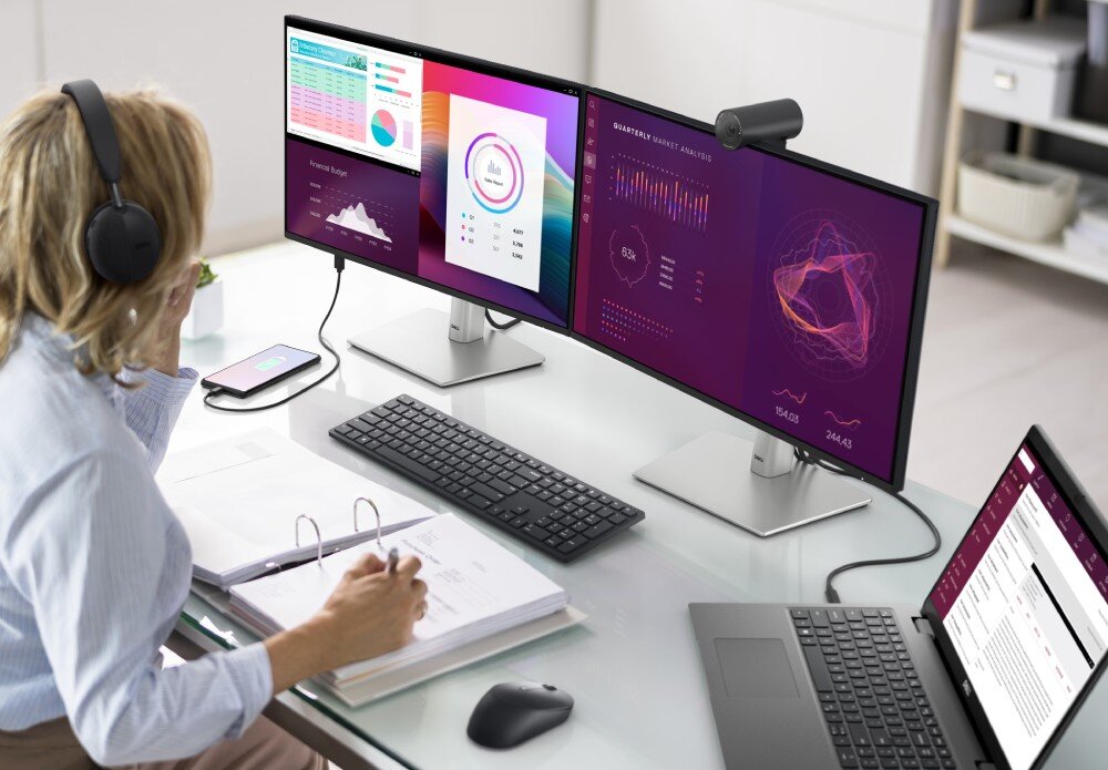 Monitor DELL P2425HE 23.8 1920×1080px IPS 100Hz osoba siedząca przy stanowisku korzystająca z laptopa, do którego podłączony jest monitor USB-C zasilanie moc 90 W RJ-45