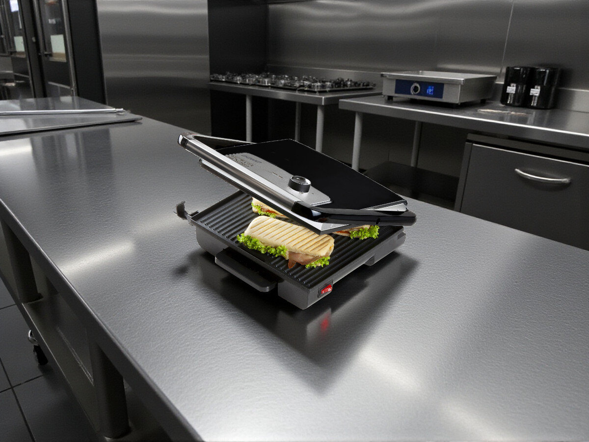 Grill elektryczny DOMO DO9245G, łatwe czyszczenie, powłoka nieprzywierająca, szuflada na tłuszcz, stal nierdzewna, Grill Domo DO9245G w profesjonalnej kuchni, otwarty, zapiekane panini z sałatą i serem na płycie grillowej, stalowy blat