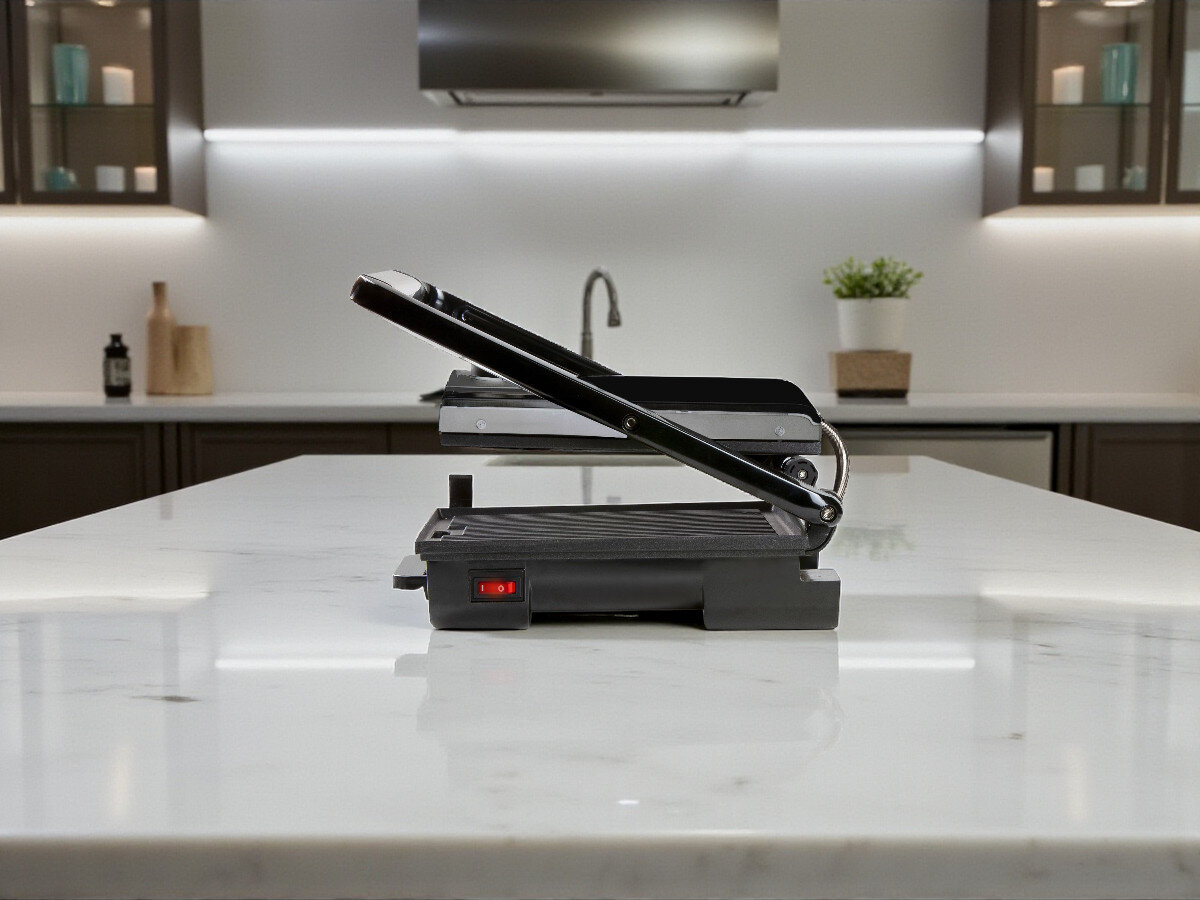 Grill elektryczny DOMO DO9245G, przechowywanie pionowe, oszczędność miejsca, lekki grill, funkcjonalny design, Widok z profilu na grill Domo DO9245G ustawiony pośrodku wyspy kuchennej, pokrywa uchylona, nowoczesna kuchnia w tle