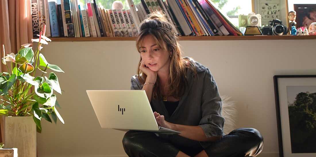 Laptop HP Pavilion 15 - Kobieta siedząca na podłodze, korzystająca z laptopa HP Pavilion 15, w atmosferze domowego spokoju.