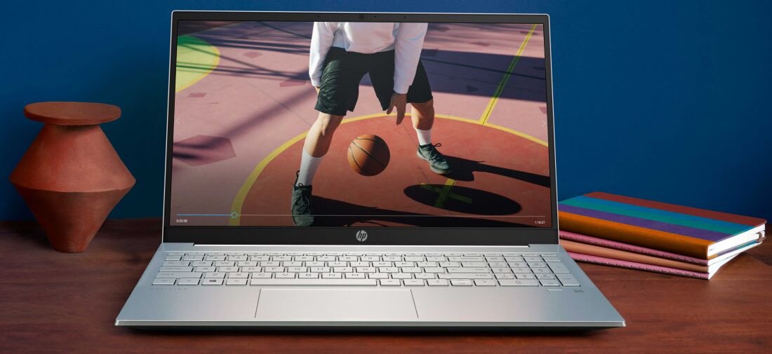 Laptop HP Pavilion 15 - Laptop HP Pavilion 15 na stole, z widocznym ekranem zawierającym obraz osoby grającej w kosza.