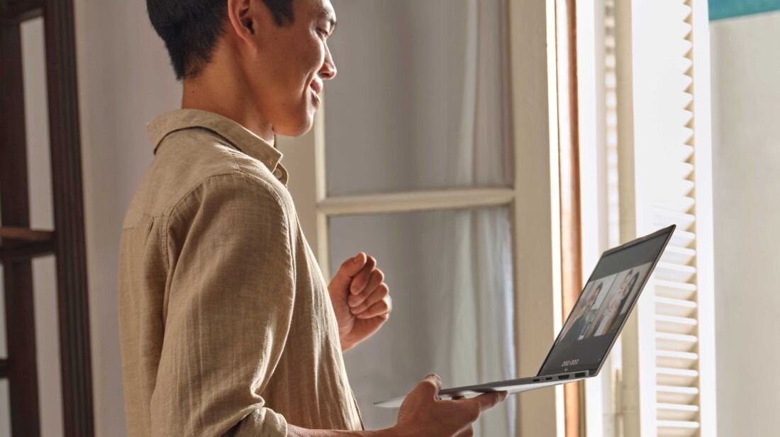 Laptop HP Pavilion 15 - Mężczyzna z laptopem HP Pavilion 15 w rękach, stojący przed oknem, w jasnym i przestronnym wnętrzu.