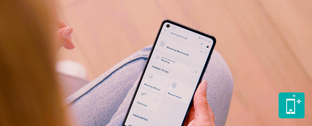 Pralka GORENJE WNS14A4TWIFI/PL lifestyle smartfon w dłoni aplikacja ikonka telefonu grafika Kreator programów aplikacja ConnectLife Kreator programów zdalne dopasowanie programów