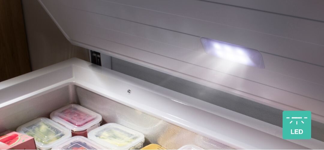 ZAMRAŻARKA GORENJE FHC42EAW Wnętrze otwartej zamrażarki skrzyniowej z włączonym oświetleniem LED na pokrywie oraz pojemnikami z mrożonkami w koszu oświetlenie LED, energooszczędne, jasne wnętrze