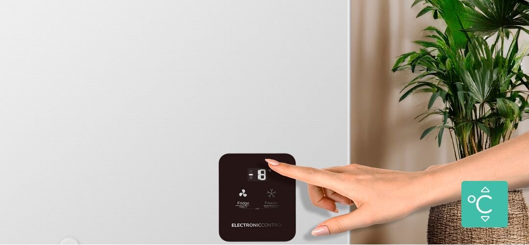 ZAMRAŻARKA GORENJE FHC42EAW Zbliżenie na panel sterowania na froncie zamrażarki skrzyniowej, dotykany palcem kobiecej dłoni, z ikoną regulacji temperatury wyświetlacz LED, regulacja temperatury, elektroniczne sterowanie