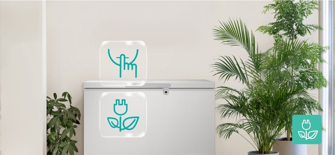 ZAMRAŻARKA GORENJE FHC42EAW Biała zamrażarka skrzyniowa stojąca we wnętrzu z kilkoma dużymi roślinami doniczkowymi, nad urządzeniem umieszczone są grafiki z ikoną cichej pracy oraz energooszczędnej wtyczki z listkiem sprężarka inwerterowa cicha praca oszczędność energii energooszczędna trwała sprężarka 40 dB