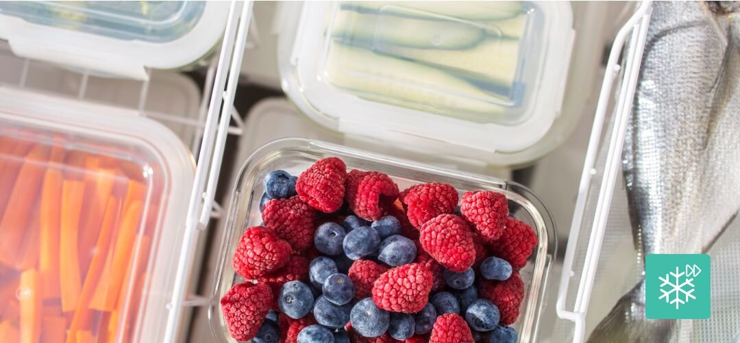 ZAMRAŻARKA GORENJE FHC42EAW Zbliżenie na szklany pojemnik z mrożonymi malinami i borówkami otoczony innymi pojemnikami z warzywami oraz rybą w zamrażarce, z ikoną mrożenia szybkie zamrażanie, -24°C, zachowanie witamin