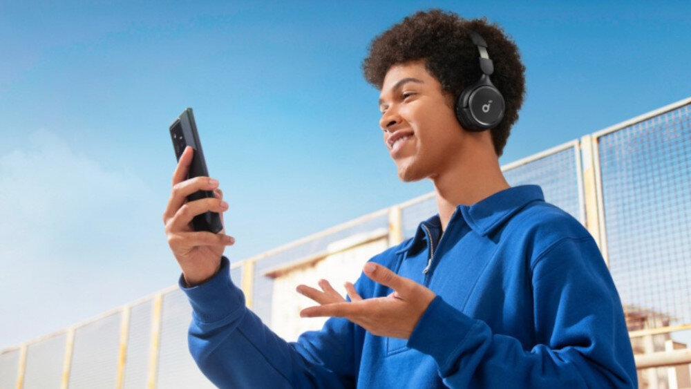 Słuchawki nauszne SOUNDCORE H30i mikrofon rozmowy głosowe przyciski sterujące, osoba z założonymi słuchawkami nausznymi z telefonem w ręku