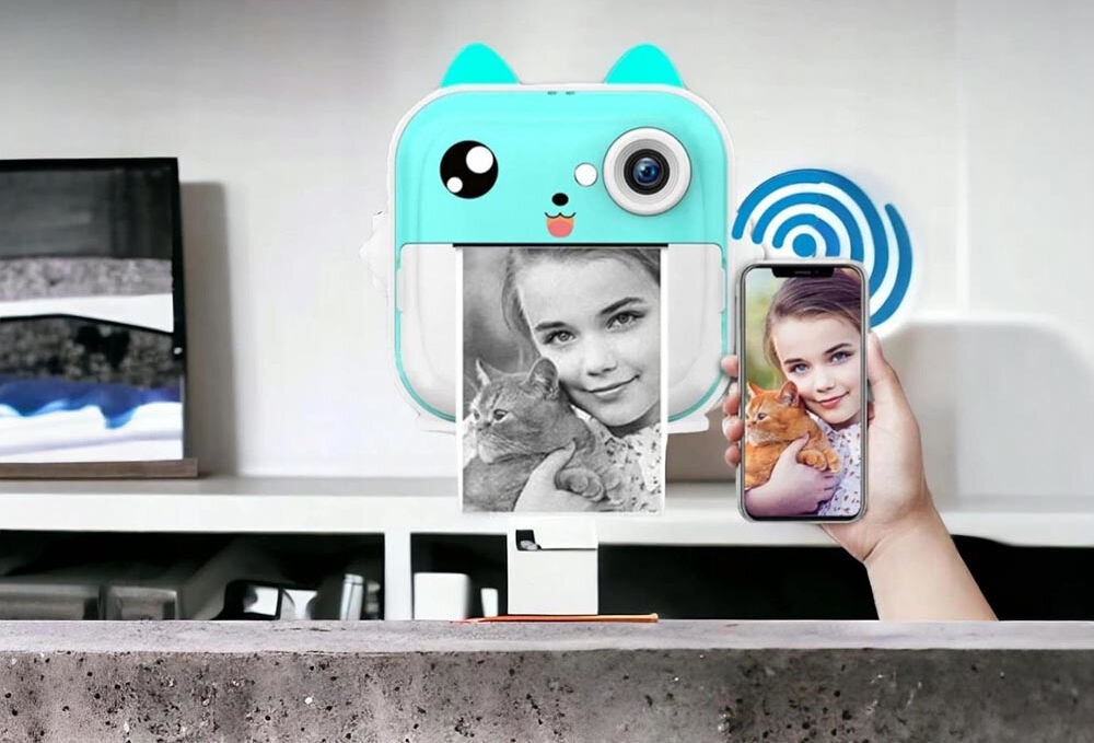 Drukarka EXTRALINK EPP-004 Złącze USB Niebieski aparat-drukarka drukujący czarno-białe zdjęcie, obok dłoń trzymająca smartfon z kolorową wersją tego samego zdjęcia Bluetooth swoboda szybkie parowanie iOS Android drukowanie zdjęć z telefonu