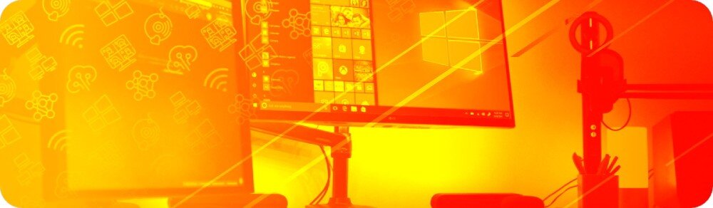 Komputer NTT HIRO Wingman ZKG-I9RTX40608G-TE24 Zdjęcie w ciepłych odcieniach żółtego przedstawiające stanowisko komputerowe z dwoma monitorami zamontowanymi na regulowanych uchwytach. Na ekranach widoczne interfejsy systemu Windows, system funkcje Interfejs gotowość