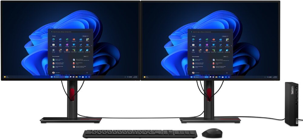 Komputer LENOVO ThinkCentre M70q Gen 5 Stanowisko pracy z dwoma monitorami ustawionymi obok siebie, centralnie umieszczoną klawiaturą i myszą oraz małą czarną obudową komputera stojącą pionowo po prawej stronie, pamięć RAM, taktowanie