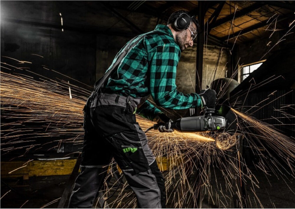 Szlifierka kątowa STALCO Perfect AG230Q S-98210 osoba używa szlifierki tnie metalowy element do cięcia do szlifowania do wygładzania powierzchni mocny silnik potężne obroty