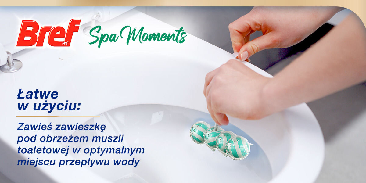 Kostka do WC BREF Spa Moments Serenity Zbliżenie na białą muszlę toaletową, gdzie dwie dłonie zawieszają niebieską kostkę Bref Spa Moments pod obręczą. Obok duży napis: Łatwe w użyciu: Zawieś zawieszkę pod obrzeżem muszli toaletowej w optymalnym miejscu przepływu wody.