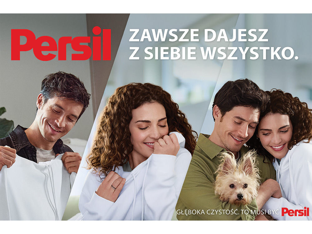Żel do prania PERSIL Zdjęcie lifestyle'owe przedstawiające cztery uśmiechnięte osoby i małego psa, otoczone miękkimi, białymi tkaninami, symbolizującymi czyste pranie. Kobieta pośrodku wącha swoją białą bluzę zadowoleniem. W nagłówku duży czerwony napis Persil i hasło: Zawsze dajesz z siebie wszystko.. Na dole widnieje napis: Głęboka czystość. To musi być Persil