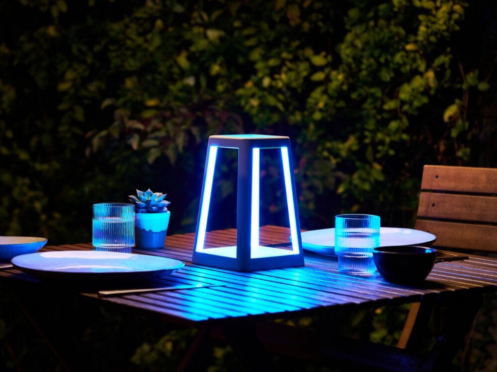 Lampa stołowa LEXON Lantern LH94W z ładowarką indukcyjną Biały lampka stoi na stole niebieskie podświetlenie obudowa z ABS-u syntetycznej skóry odporna na zachlapania na tarasie na balkonie port USB-C pełne ładowanie trwa około 4 godzin czas działania do 8 godzin design funkcjonalność mobilność oświetlenie w każdych warunkach 